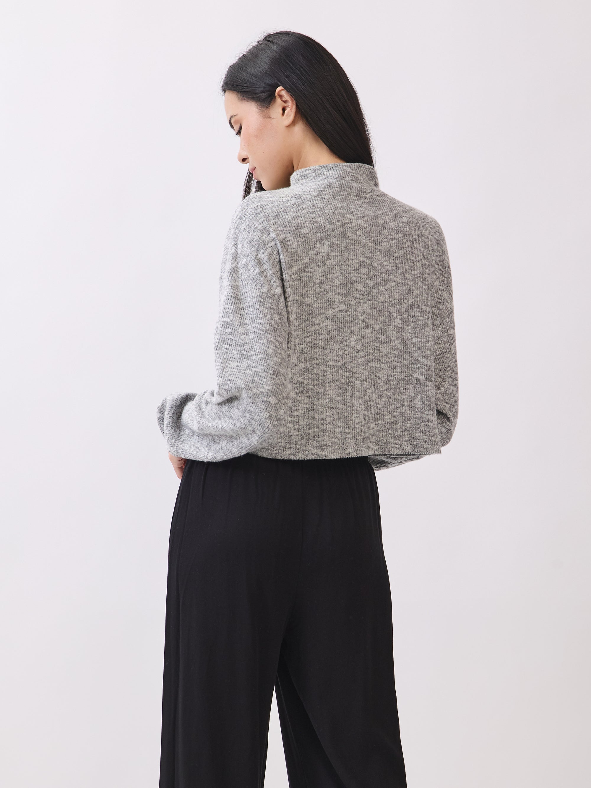 Back view of model wearing the BTTRMMT Elina High Neck Sweater, featuring a soft gray knit and relaxed cropped fit.