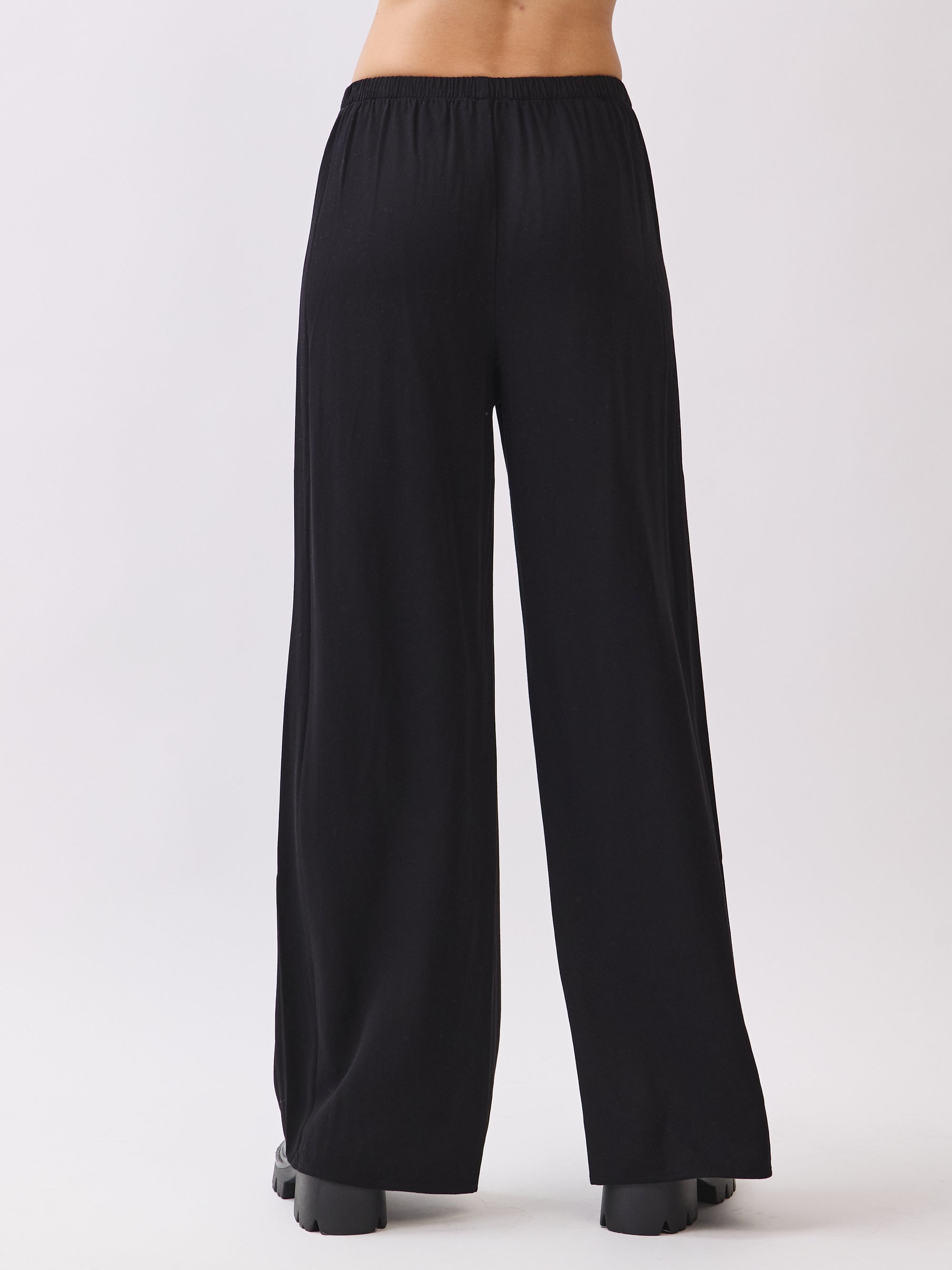 BTTRMMT Black Calia Pants shown from the back, featuring a relaxed wide-leg fit with a soft drape for comfy everyday style.