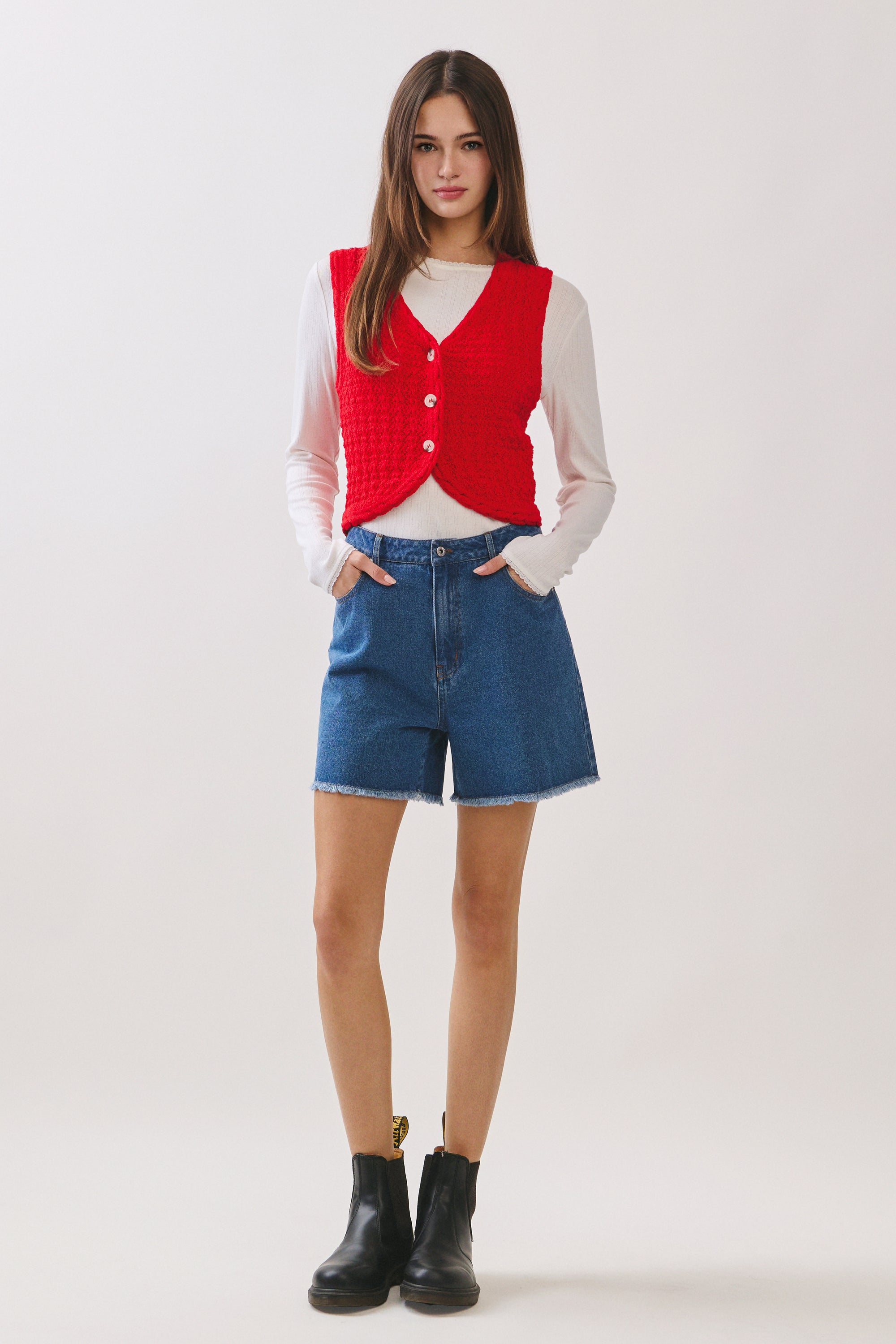 BTTRMMT Rhea Knit Vest front view featuring red button-front knit vest layered over long sleeve top