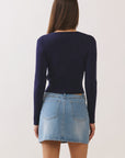 Back view of model wearing BTTRMMT Alina Vneck Sweater in navy, slim ribbed fit with cropped length.
