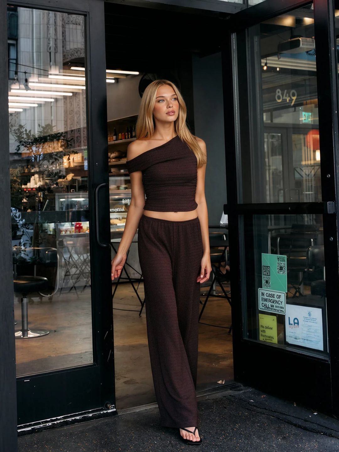 Model wearing the BTTRMMT Daniela Off-Duty Set in brown, in a one-shoulder ruched top and wide-leg pants.
