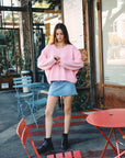 BTTRMMT Pink Millie Cardigan front view worn in downtown Los Angeles with button-front design and relaxed cozy fit