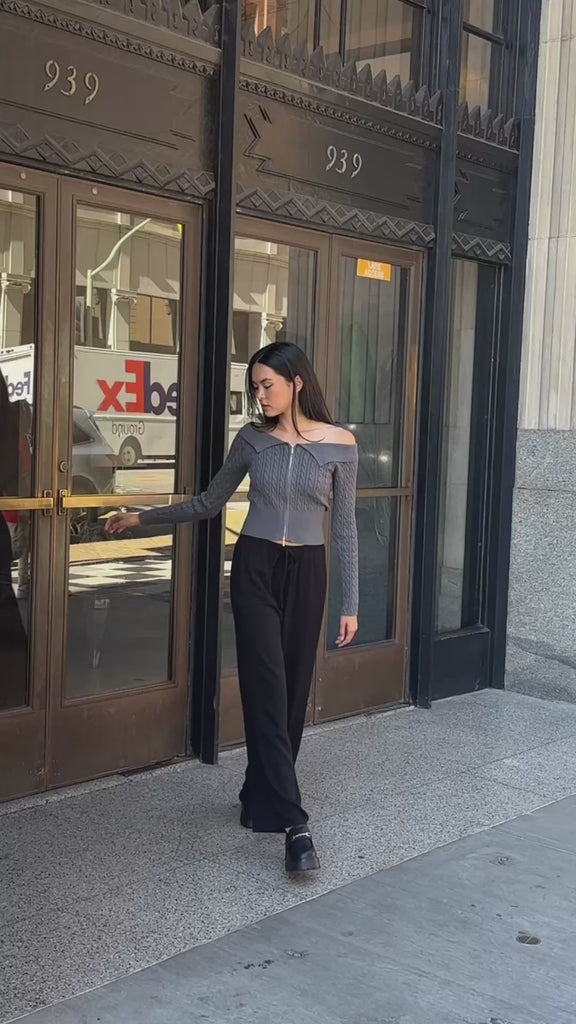 Video clip of BTTRMMT model walking outside in the Camille Zip Knit, styled with black wide-leg pants and loafer.